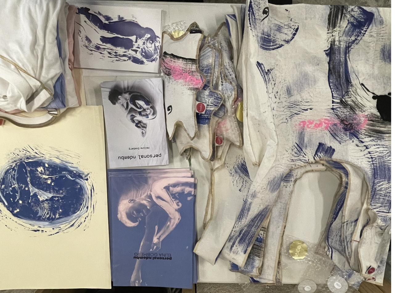 Monotype-printed textiles and books, flat lay